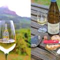 A glass of Pouilly-Fuissé Burgundy wine in front of the Solutré Rock, and a table with toasts and glasses of wine